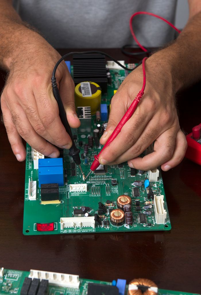 Mastering the First Impression: Your intriguing post title goes here Close-up of hands using probes to test a circuit board during electronic repair.